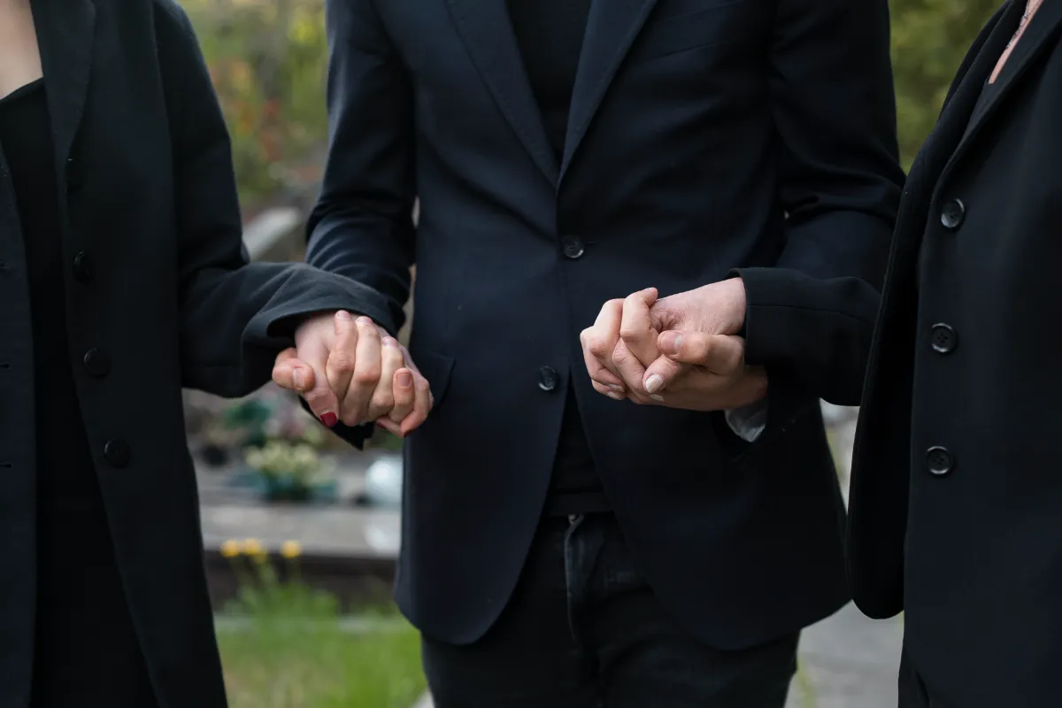 pessoas de mãos dadas em um momento de apoio ao luto