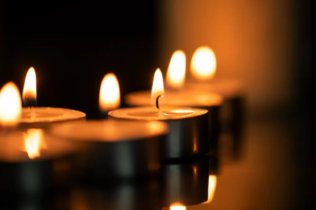 velas acesas em ambiente escuro, simbolizando luto e homenagens em cerimônias de cremação