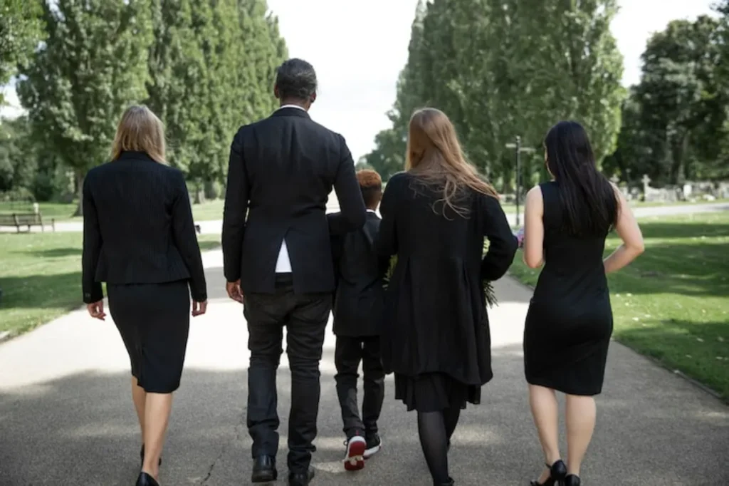 Família caminhando em direção ao local da cerimônia, representando o investimento em plano funerário familiar.