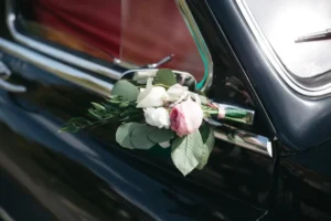 Traslado de corpo com carro funerário e flores